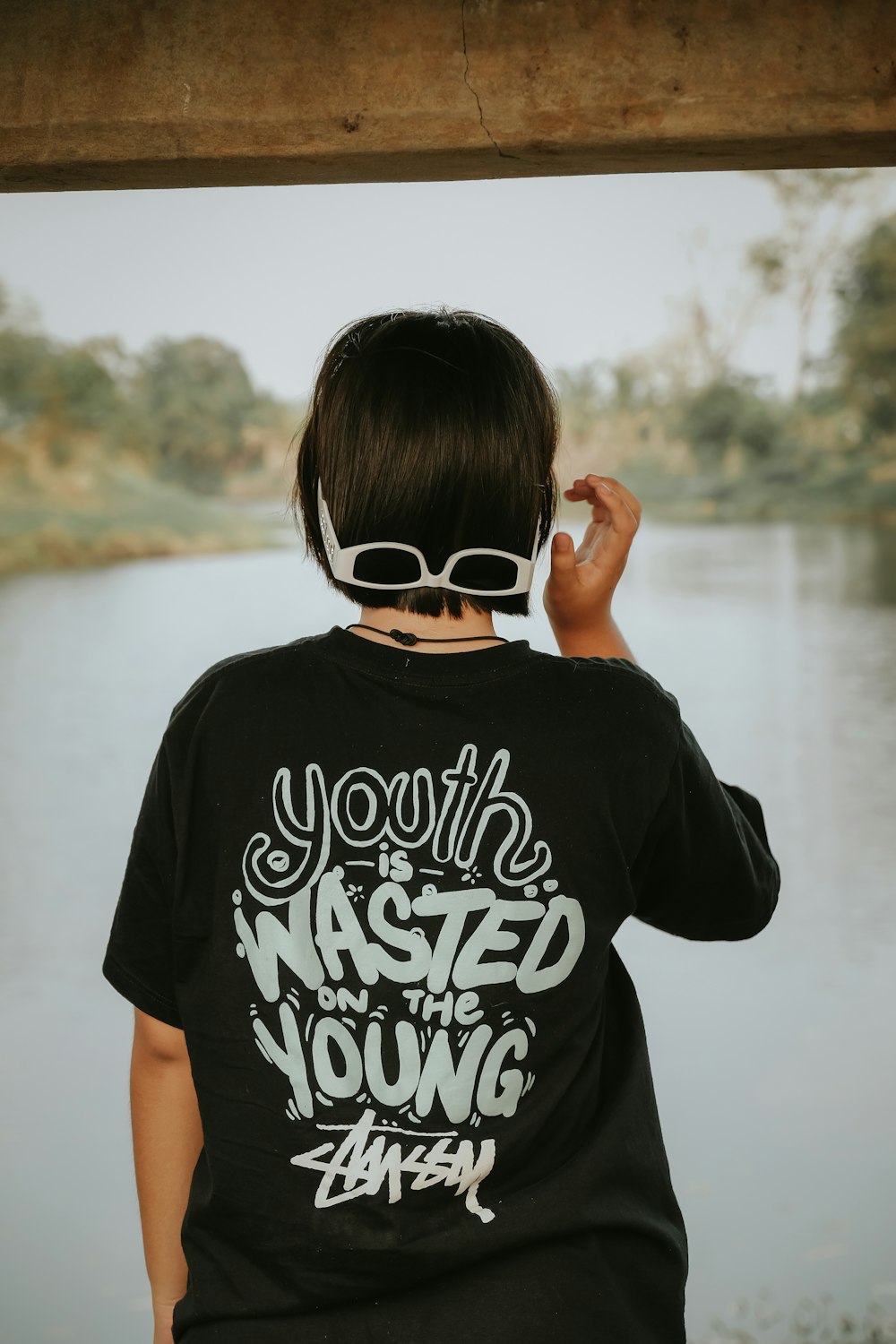 a young boy wearing a t - shirt that says youth is wasted young
