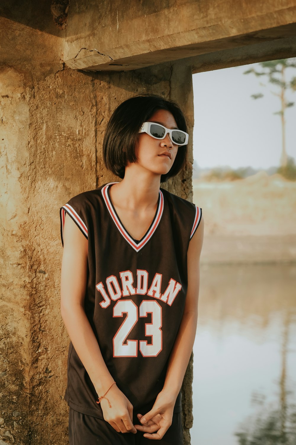 a woman wearing a basketball uniform and sunglasses