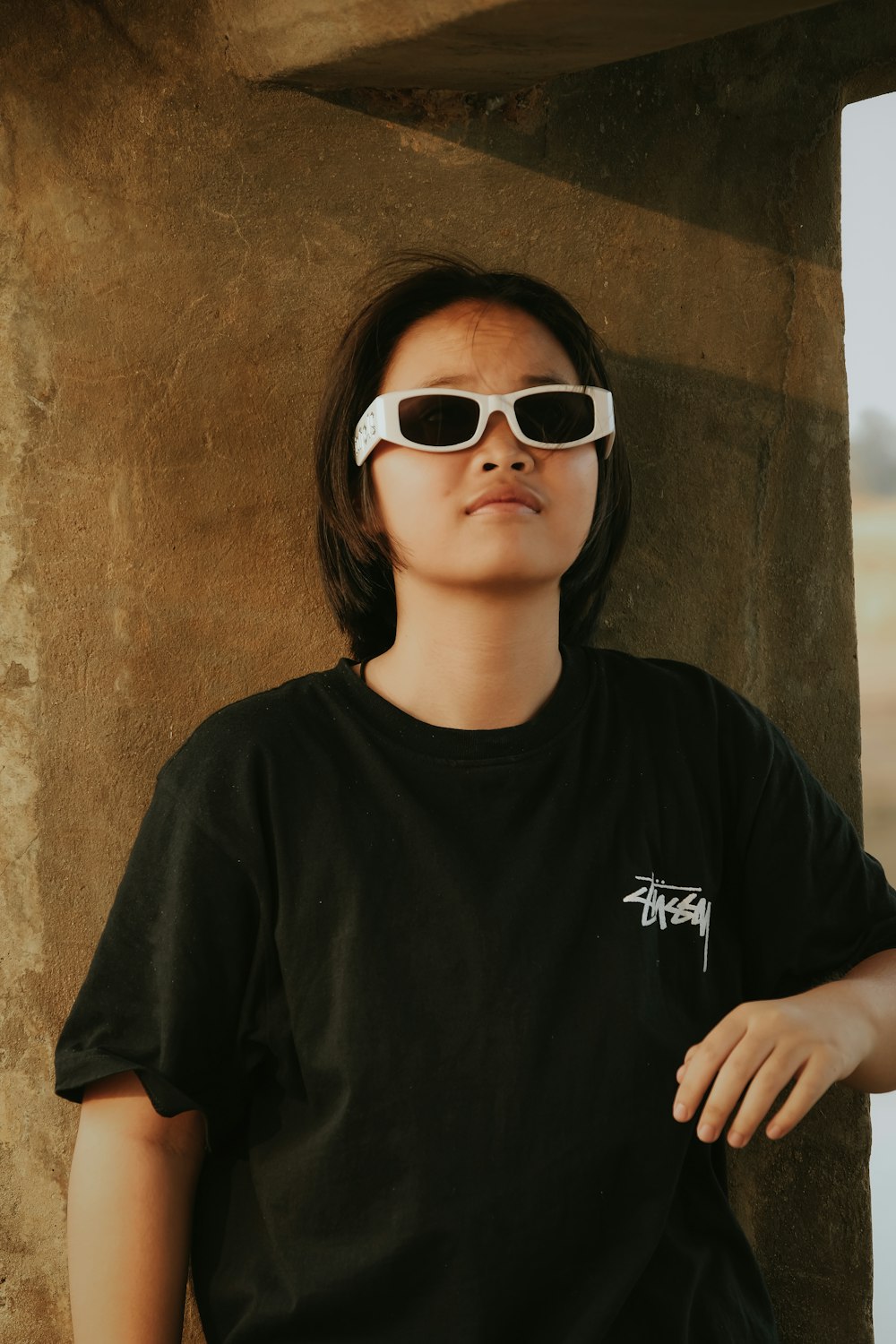 a woman wearing a black shirt and white sunglasses