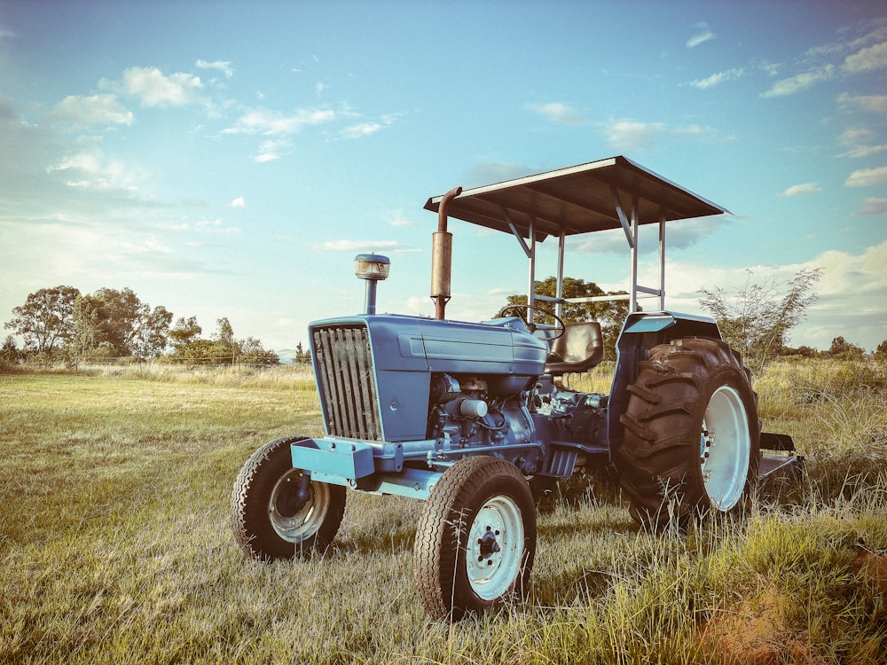a blue tractor is parked in a field
