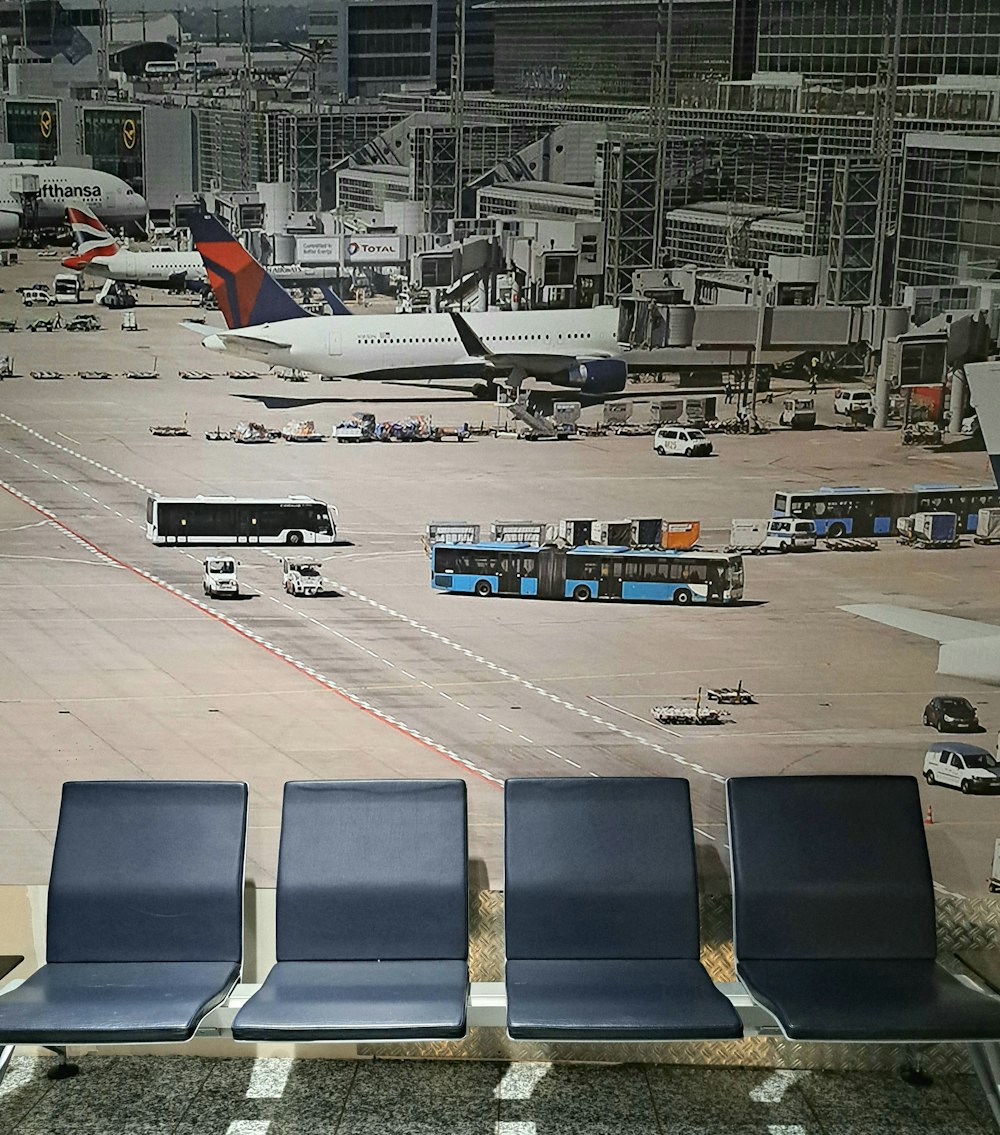 a row of blue chairs sitting in front of an airport