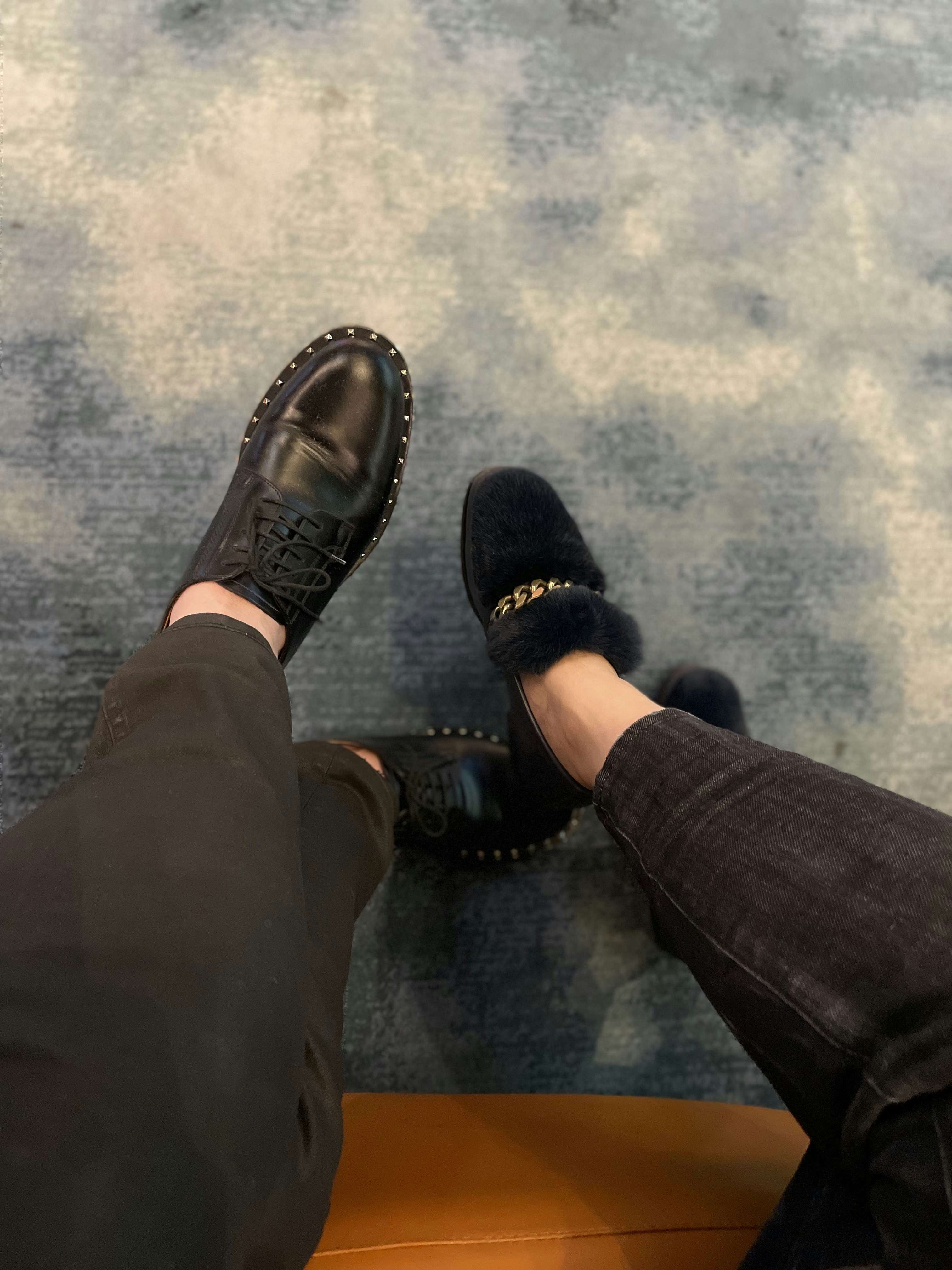 a person wearing black shoes and a pair of black pants