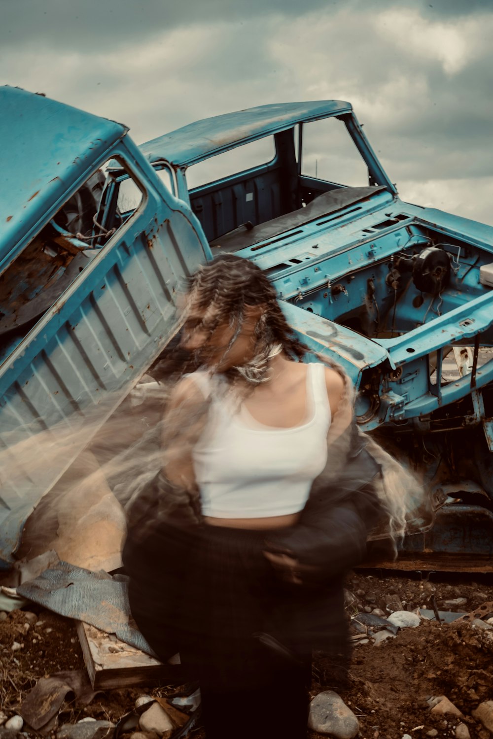 a woman standing in front of a blue truck