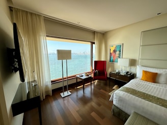 a hotel room with a large window overlooking the water