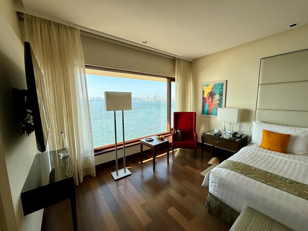 a hotel room with a large window overlooking the water