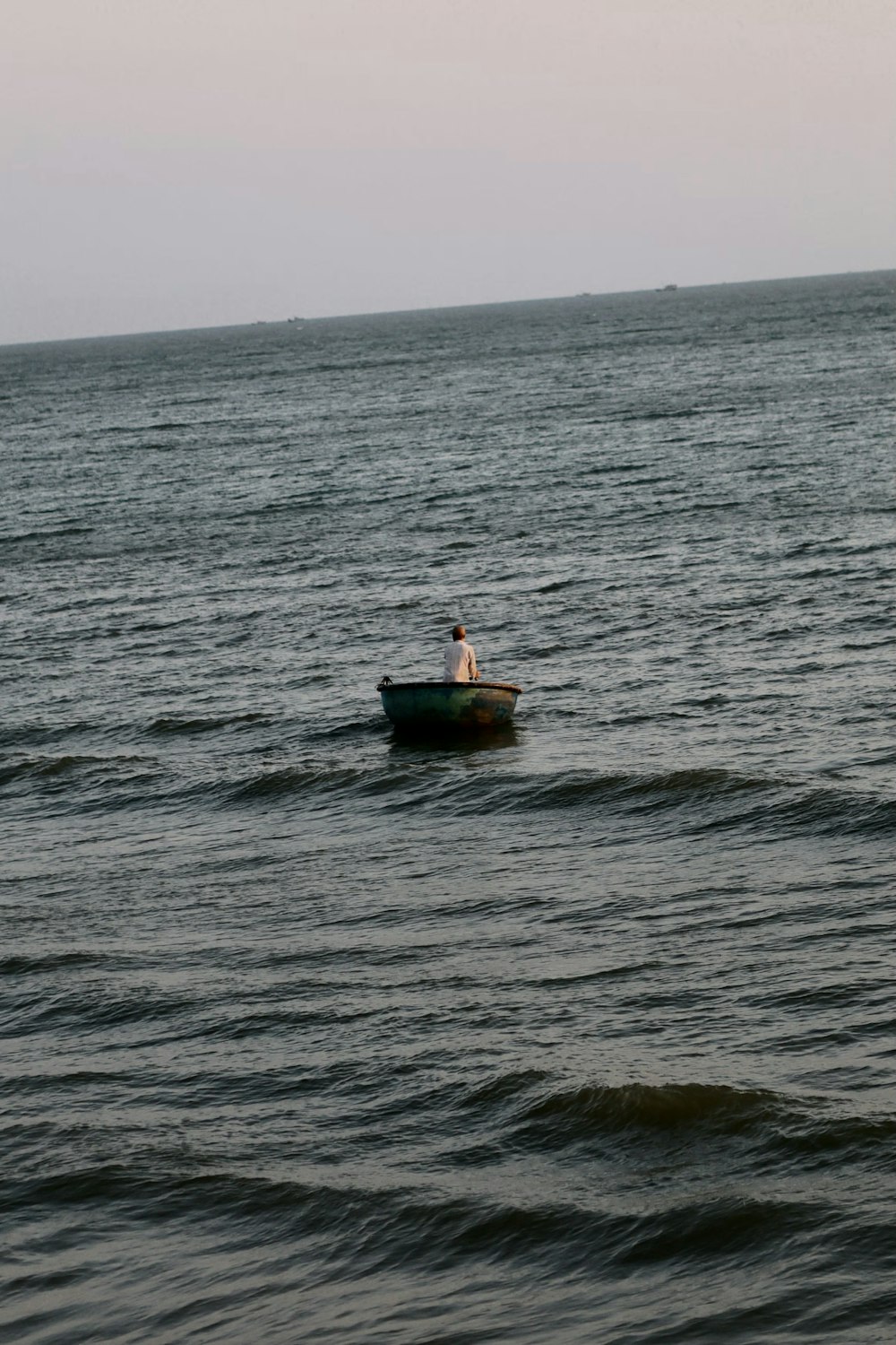 a person in a small boat in the middle of the ocean