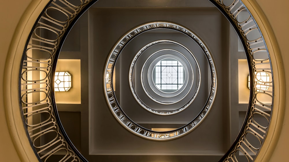 um espelho circular refletindo uma janela em um quarto