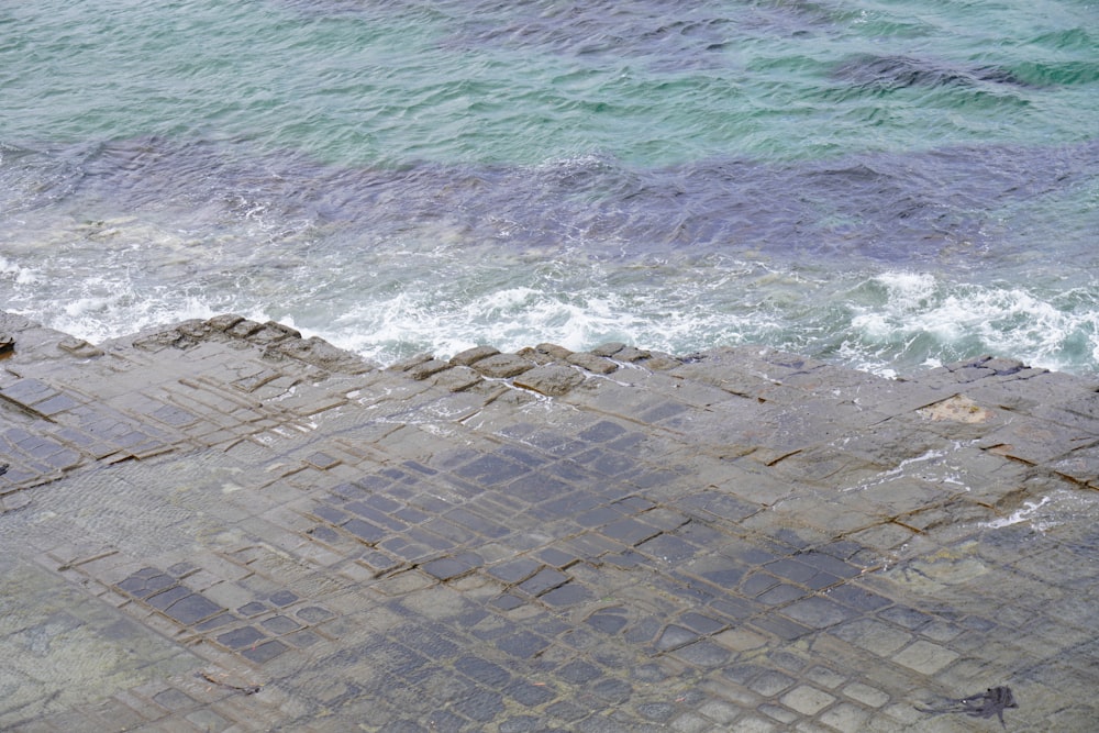 a man sitting on a bench next to the ocean