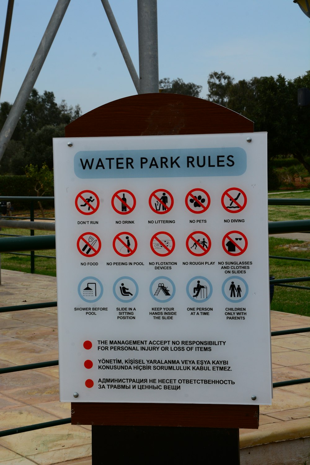 Un letrero de reglas de parque acuático frente a un parque