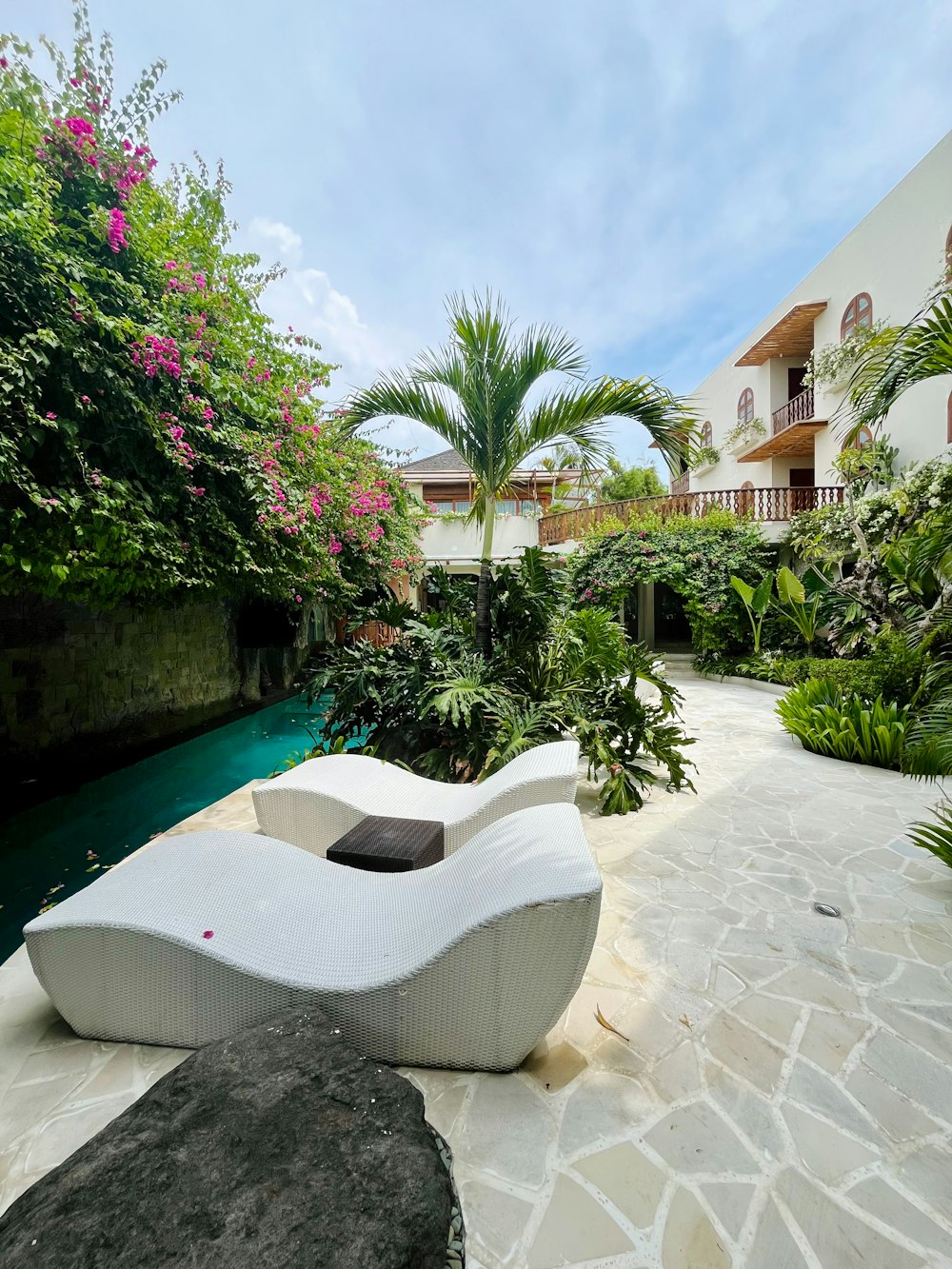 a white couch sitting on top of a stone walkway