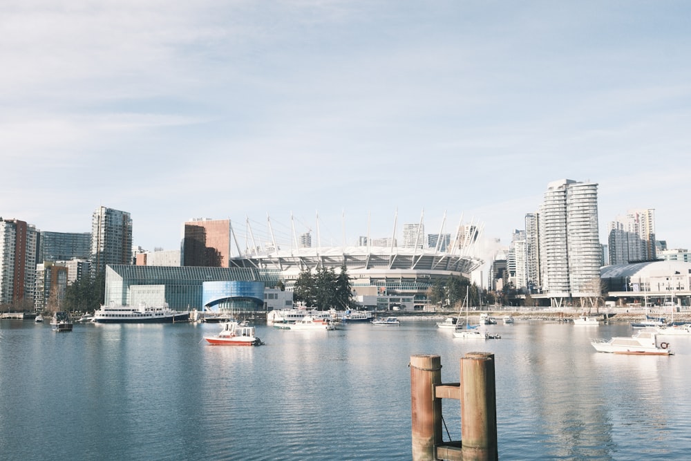 a harbor filled with lots of boats next to tall buildings