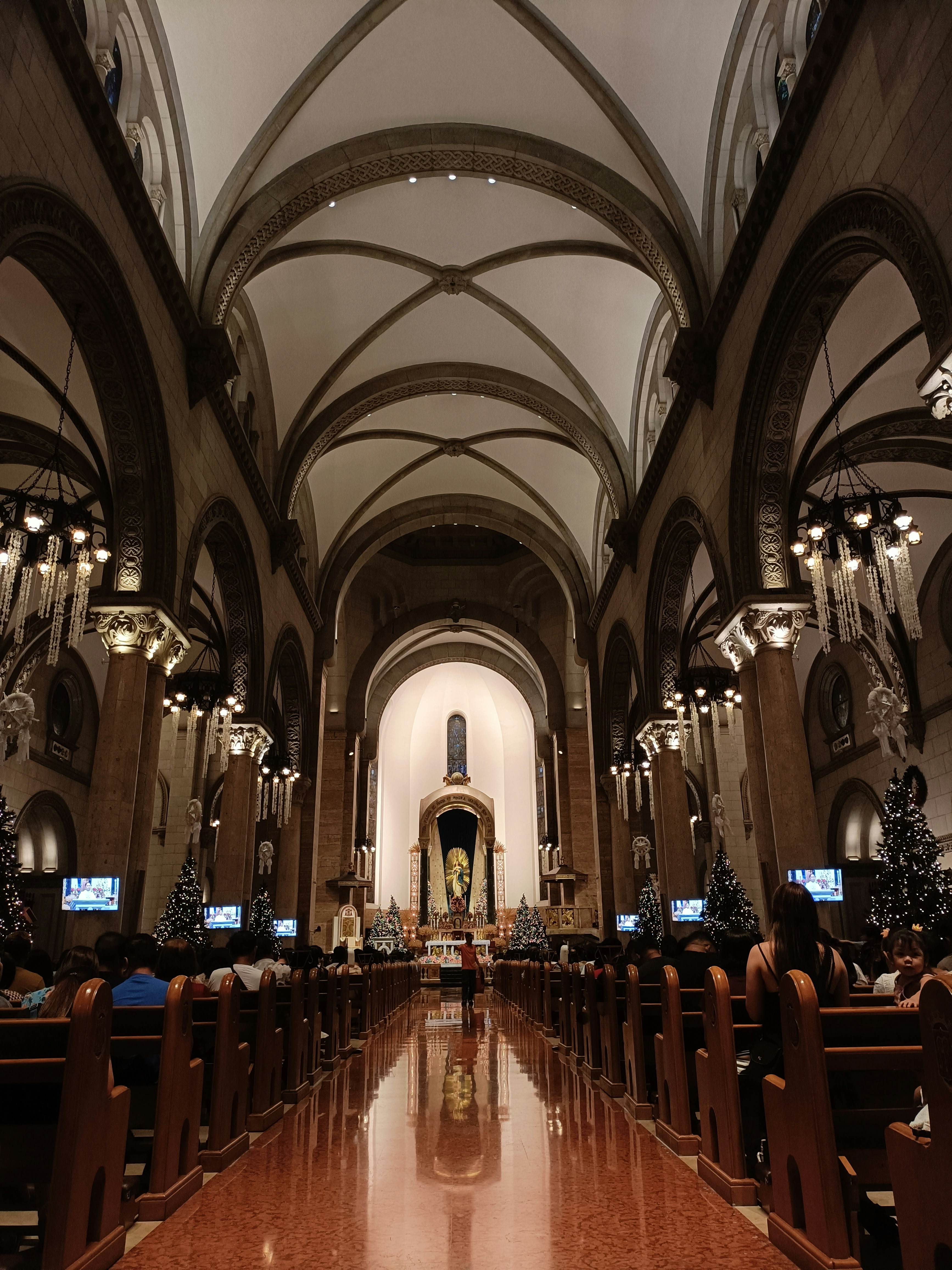 Eine Kirche mit vielen Kirchenbänken, die weihnachtlich geschmückt sind