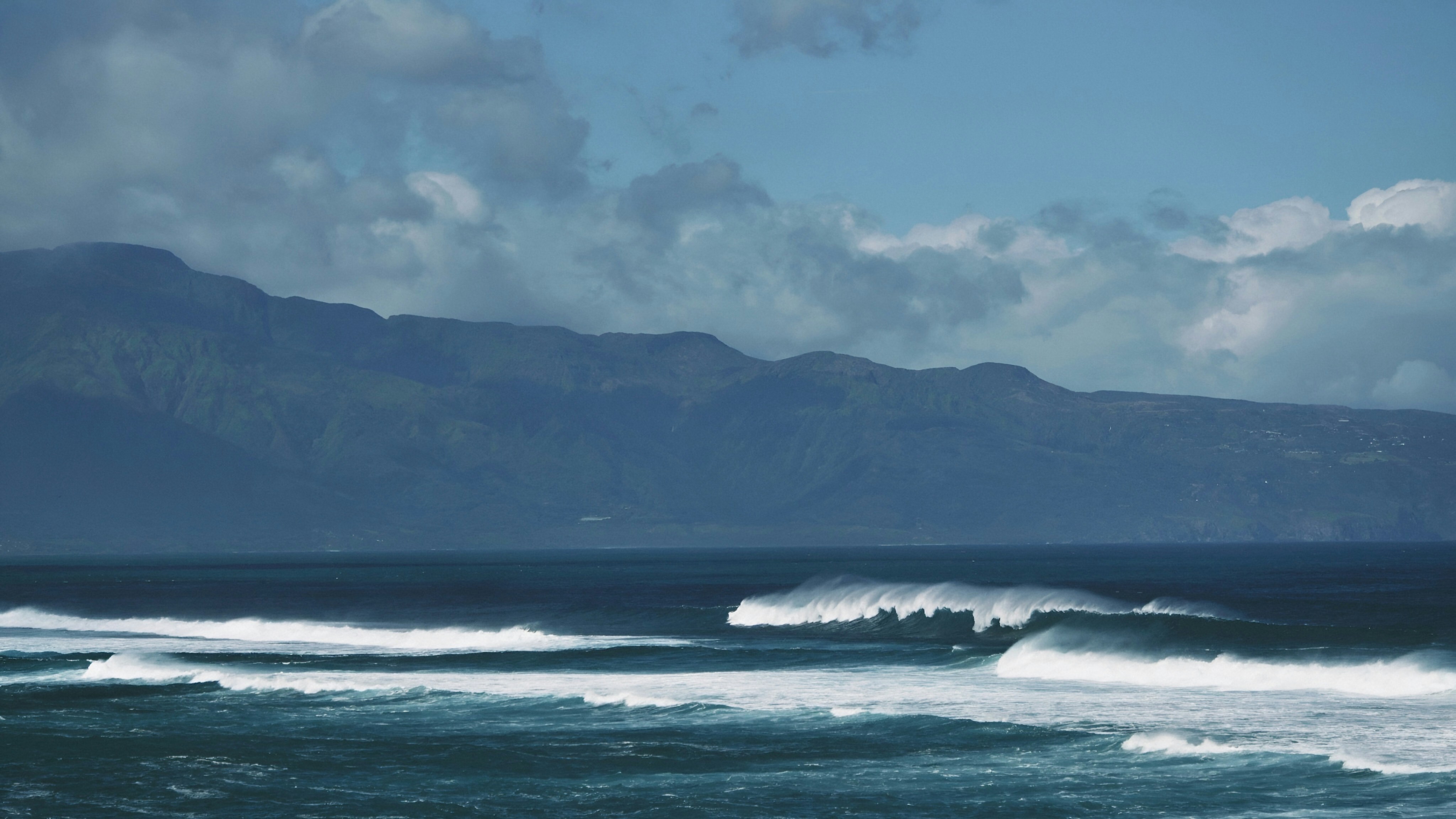 a large body of water with mountains in the background
