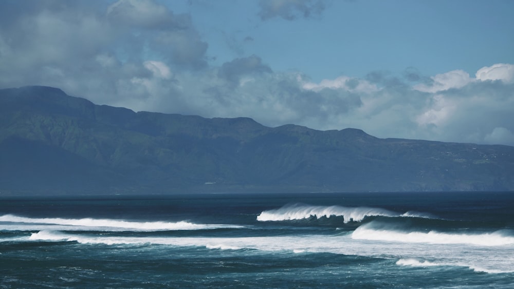 a large body of water with mountains in the background