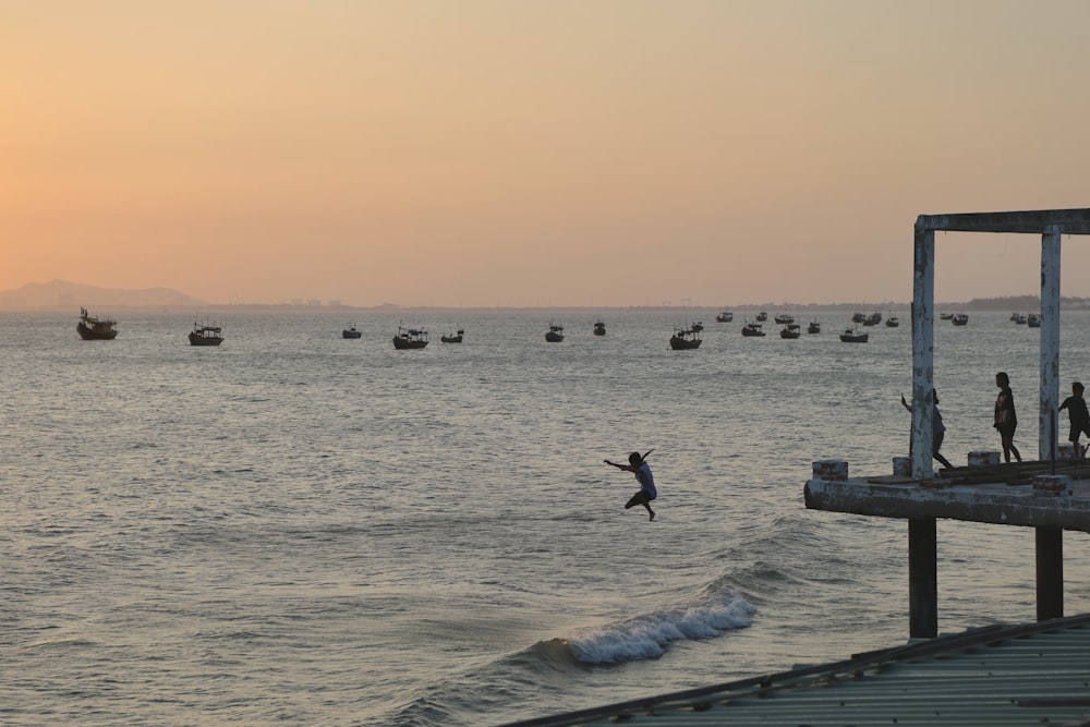 a group of people standing on top of a body of water