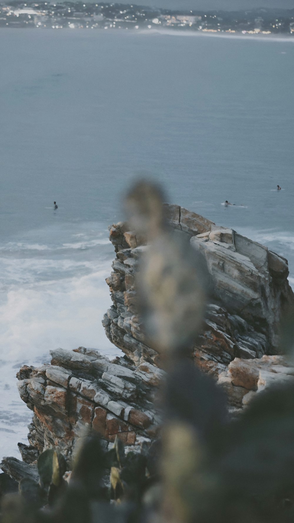 a man standing on top of a cliff next to the ocean