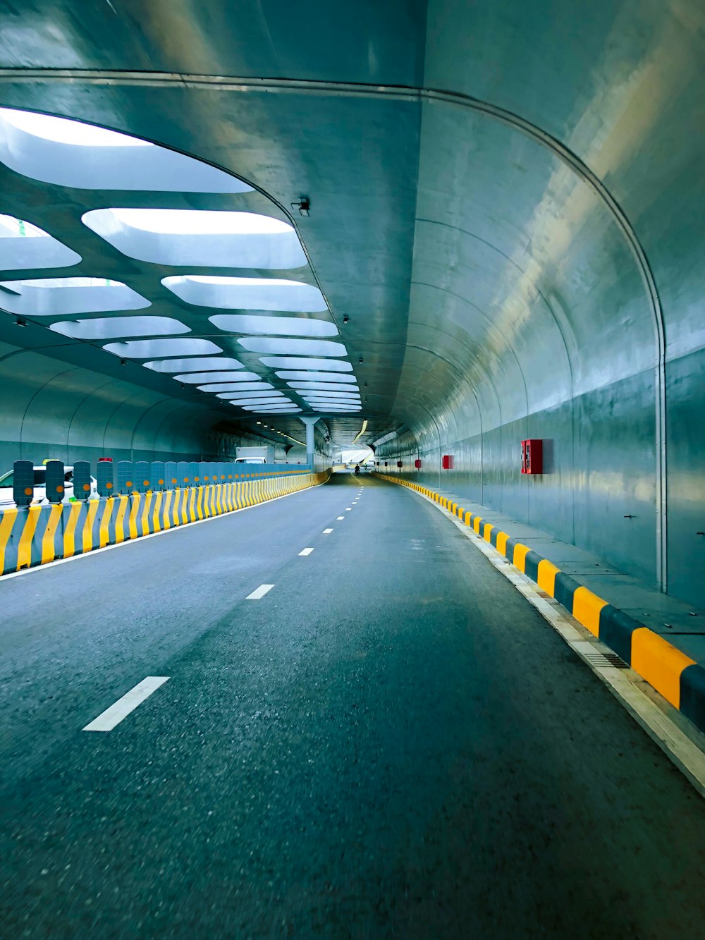 a long tunnel with yellow and black barriers
