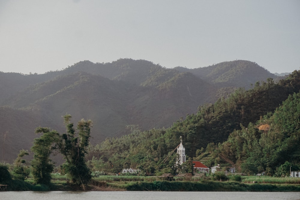 a church in the middle of a lake surrounded by mountains