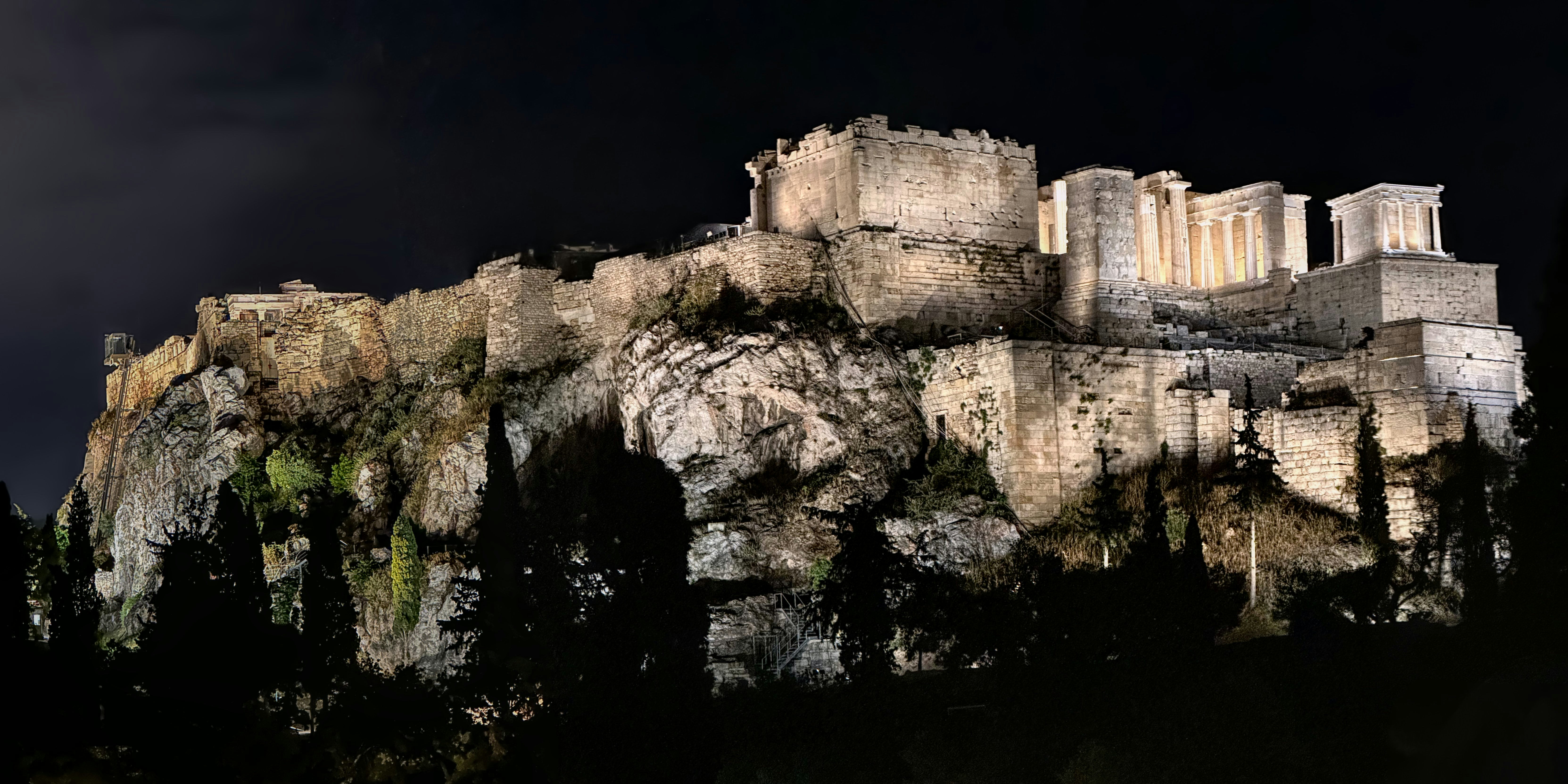 Una scena notturna di un castello in cima a una montagna
