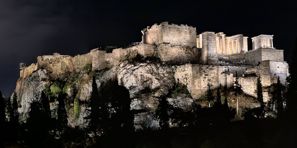 a night scene of a castle on top of a mountain