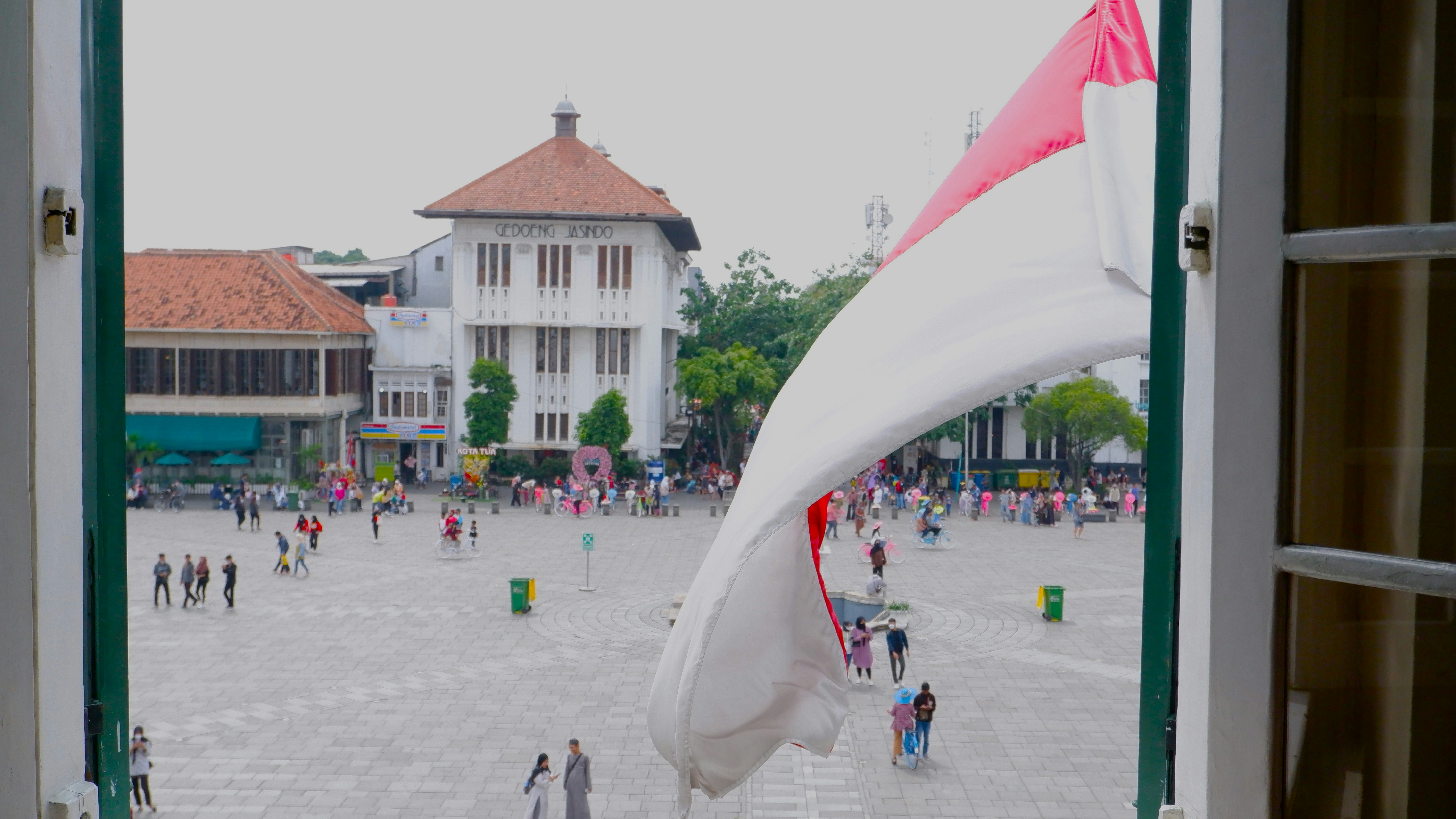 pintu terbuka dengan bendera di tengah halaman