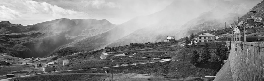 a black and white photo of a mountain road