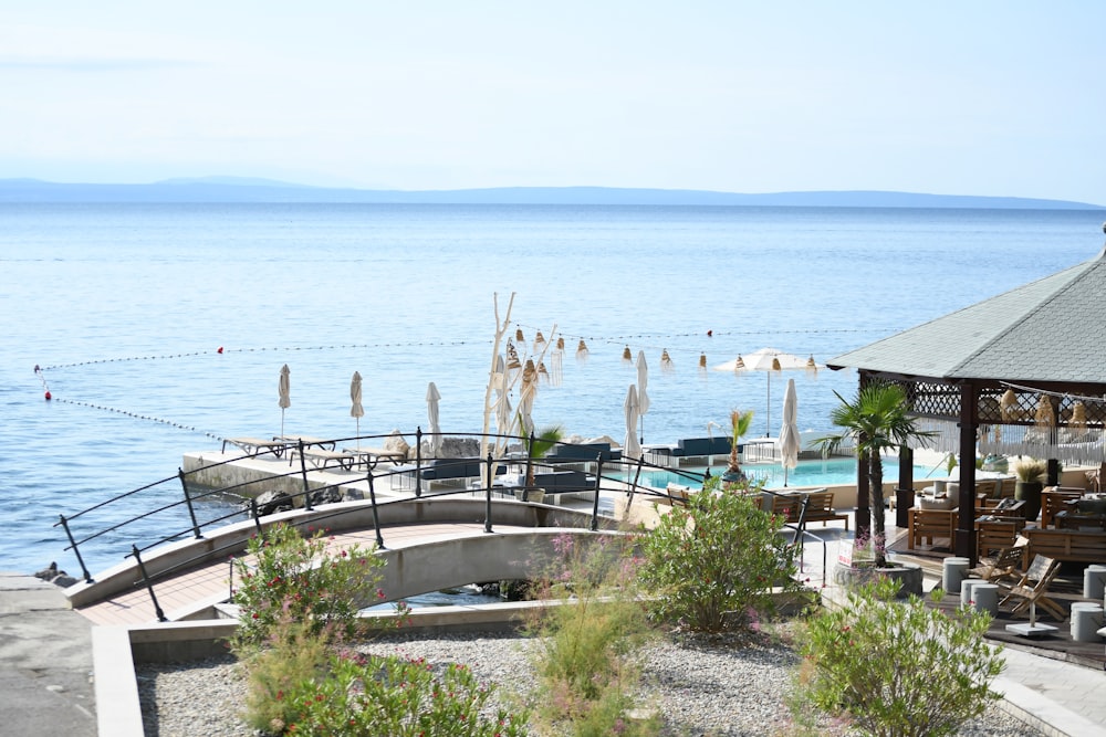 a gazebo sitting on top of a beach next to a body of water