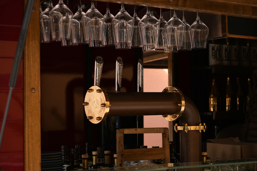 a bunch of wine glasses hanging from a bar