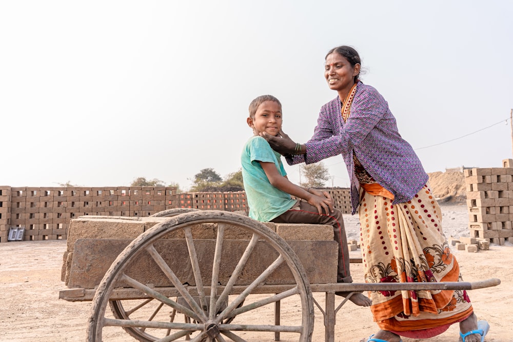 a woman pushing a cart with a child on it