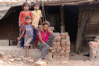 a group of children sitting on top of a pile of bricks