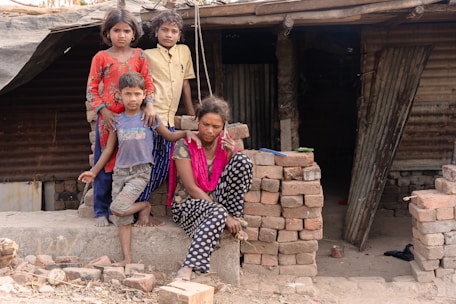 a group of children sitting on top of a pile of bricks