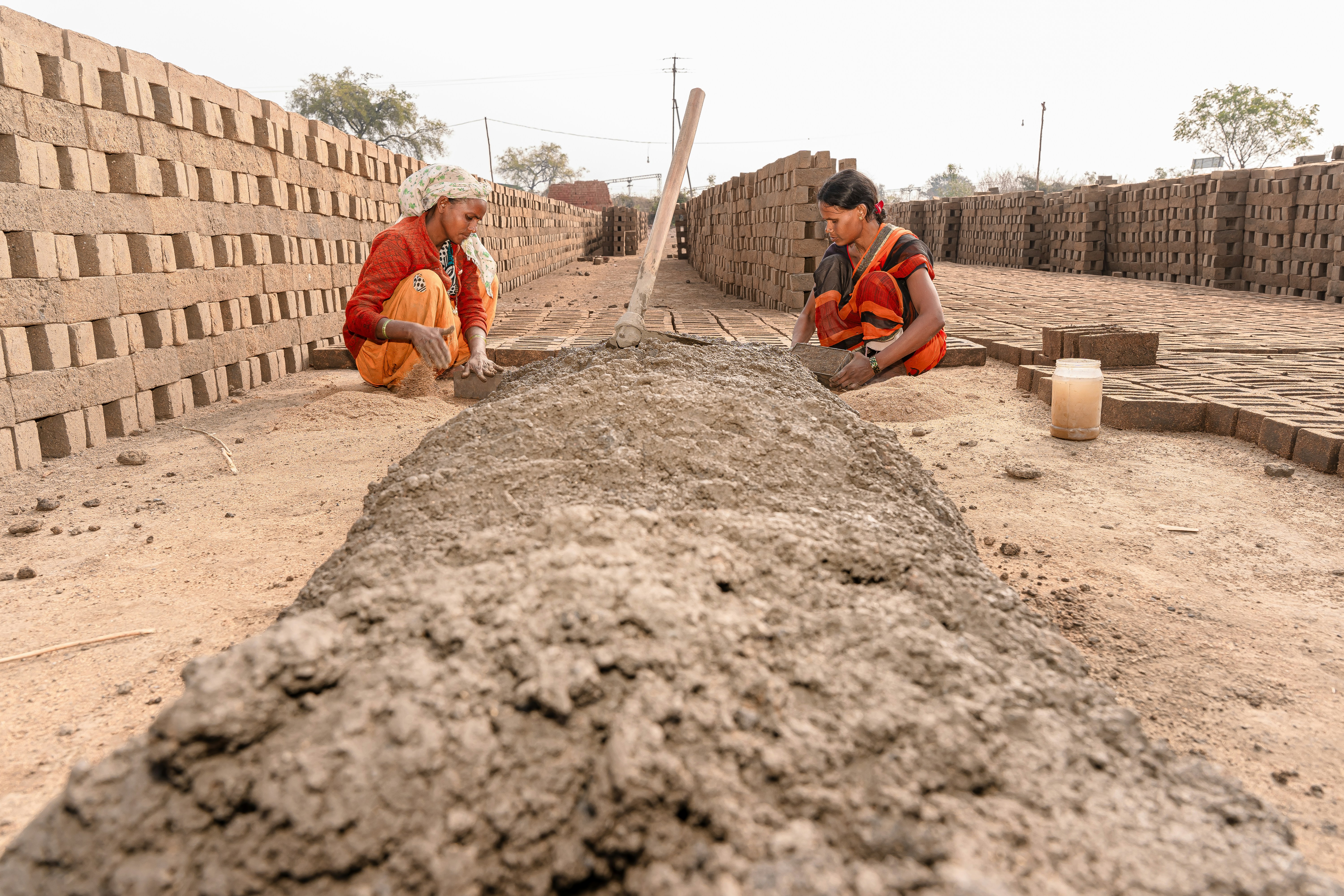 a couple of men standing next to a pile of dirt