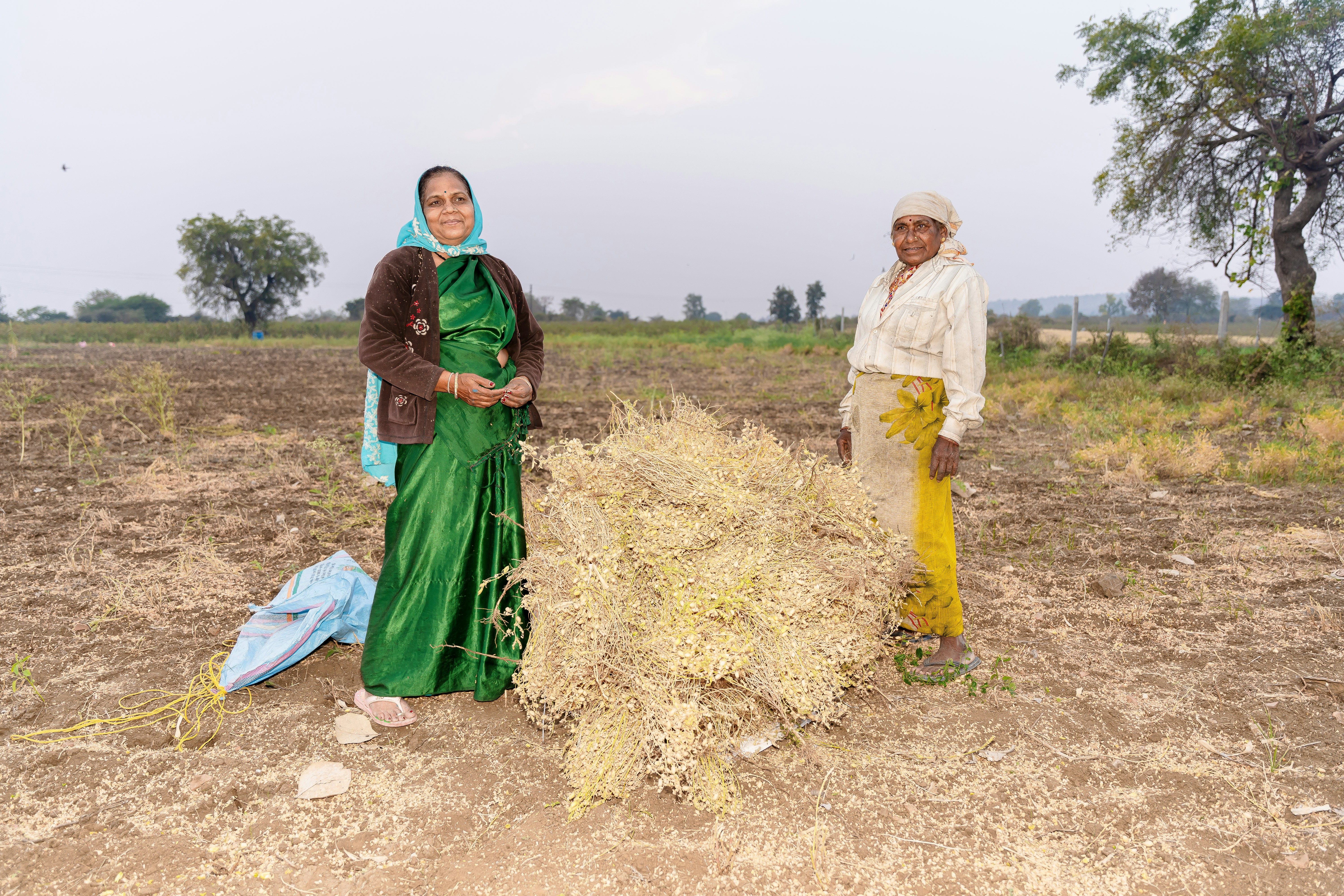 a couple of women standing next to each other in a field