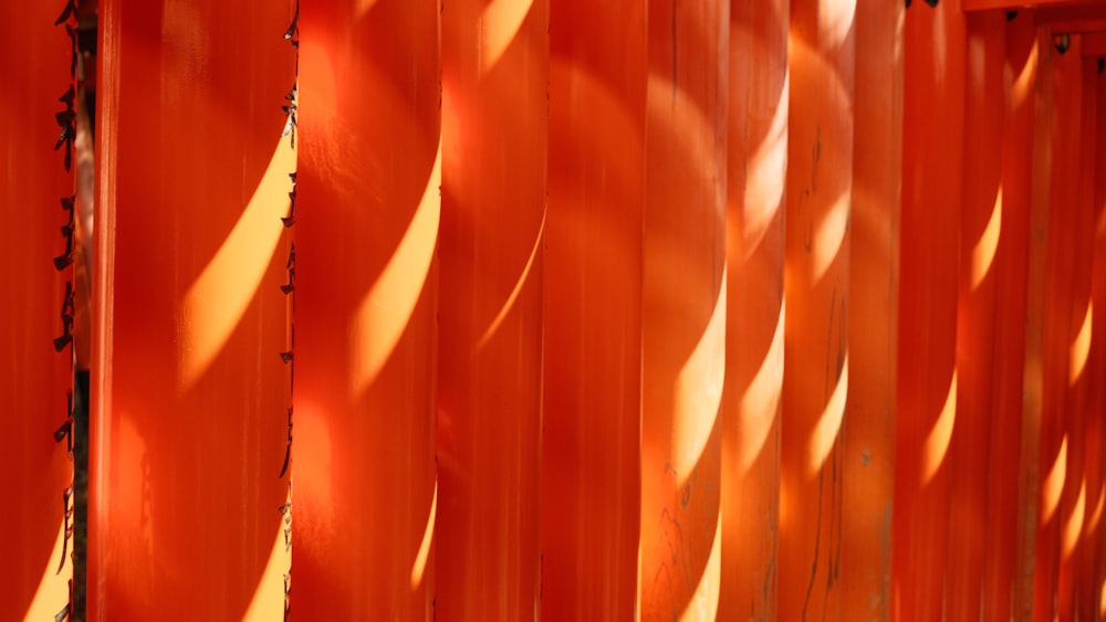 Un primer plano de una pared naranja con largas sombras