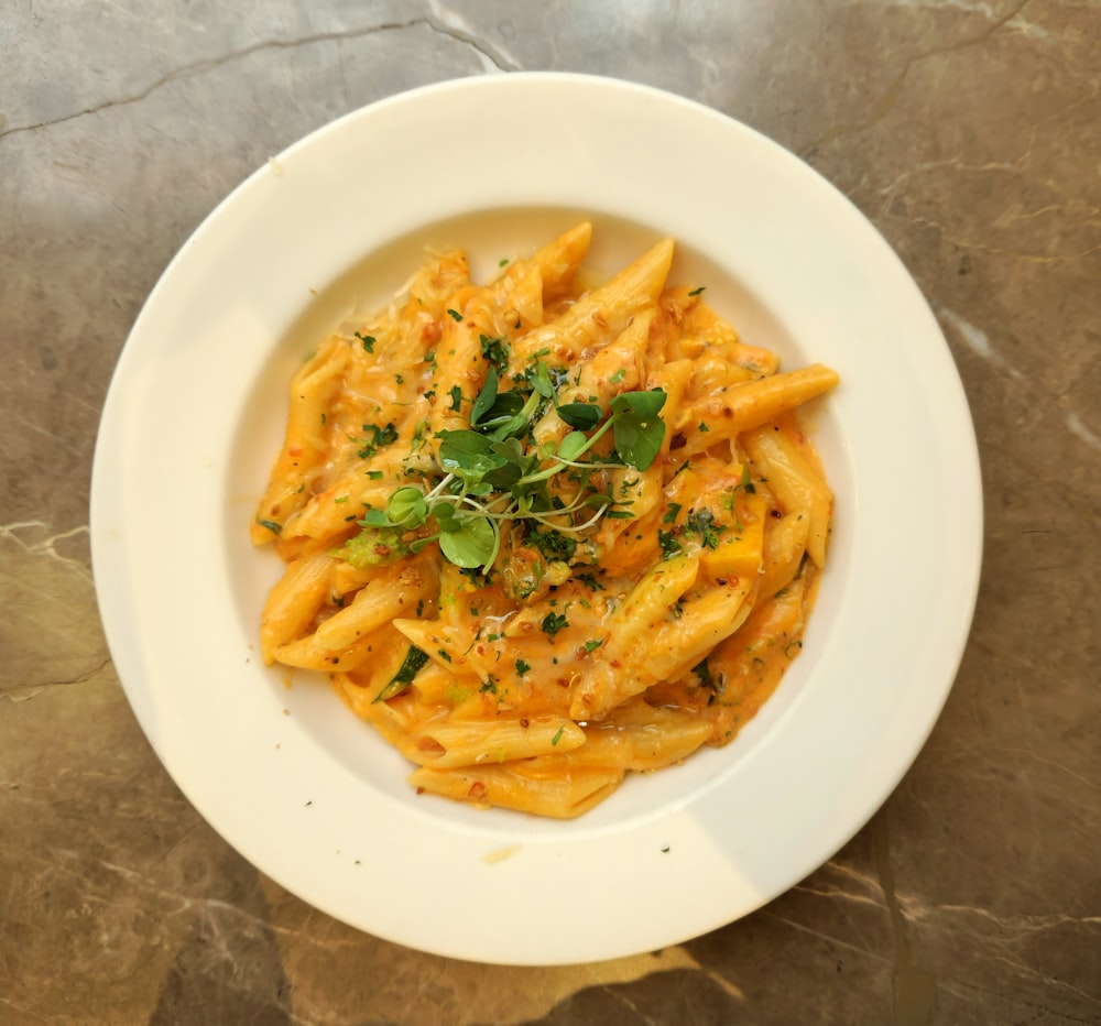 a white plate topped with pasta covered in sauce