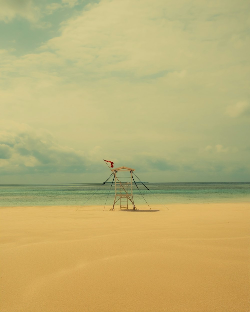 a windmill sitting on top of a sandy beach