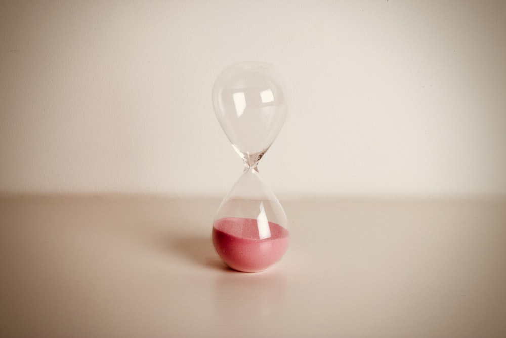 an hourglass with a red sand inside of it