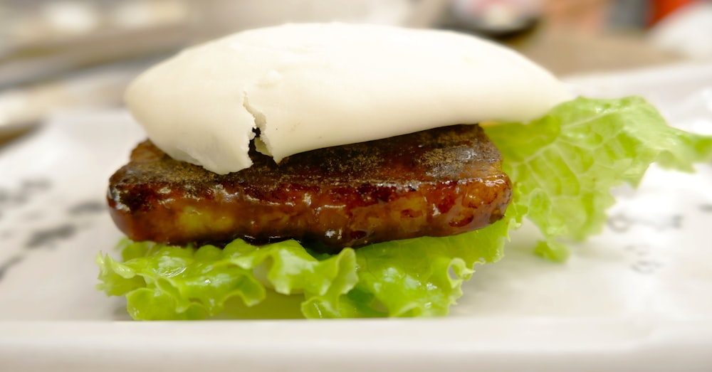 a close up of a plate of food with meat and lettuce