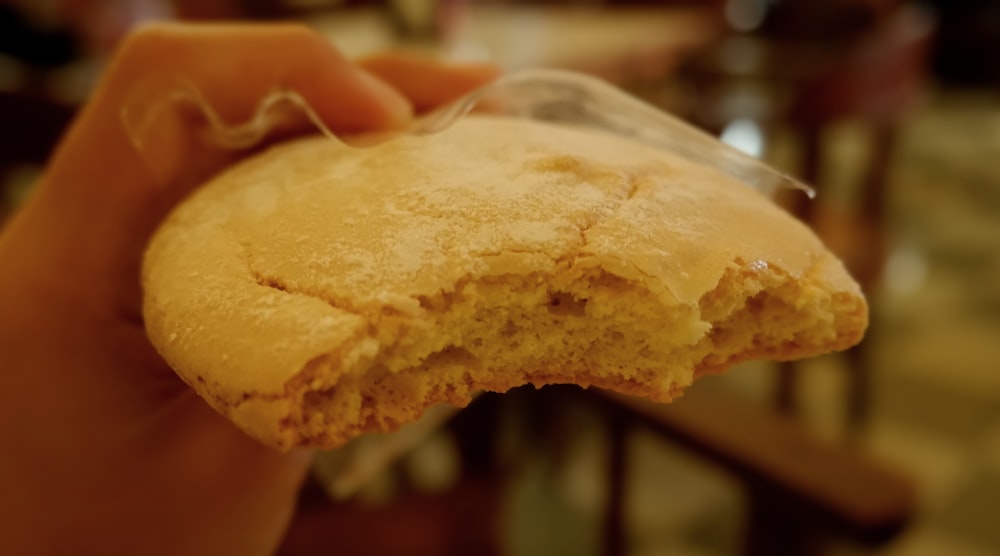 a close up of a person holding a piece of food