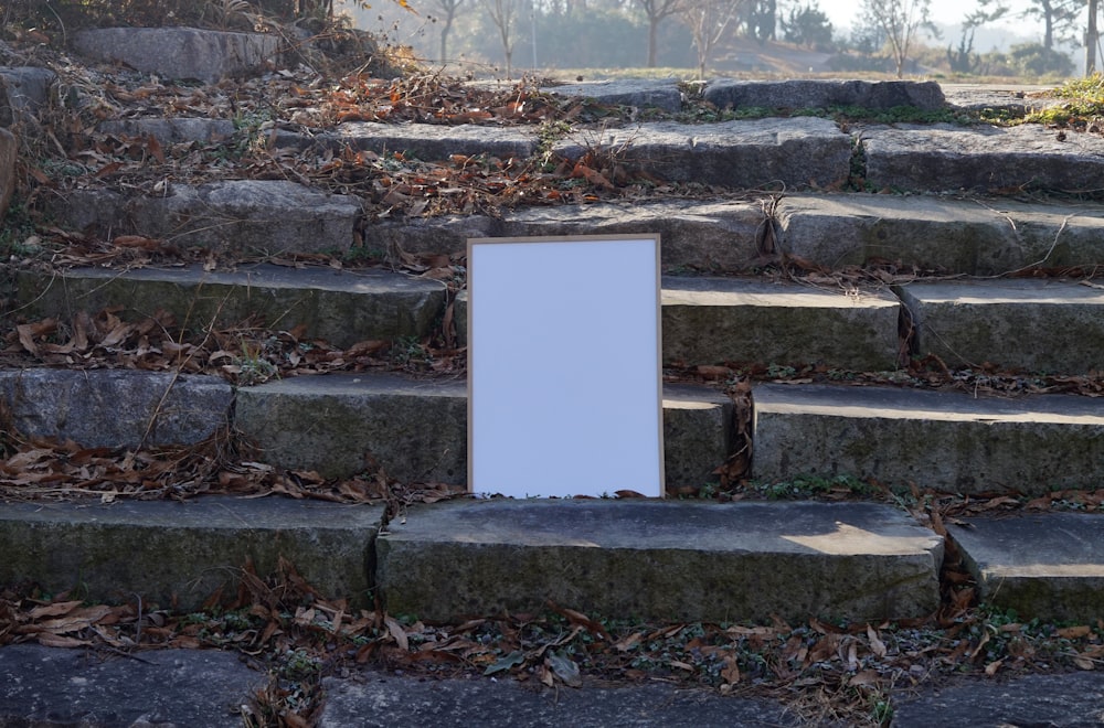 a white sign sitting on top of a set of steps
