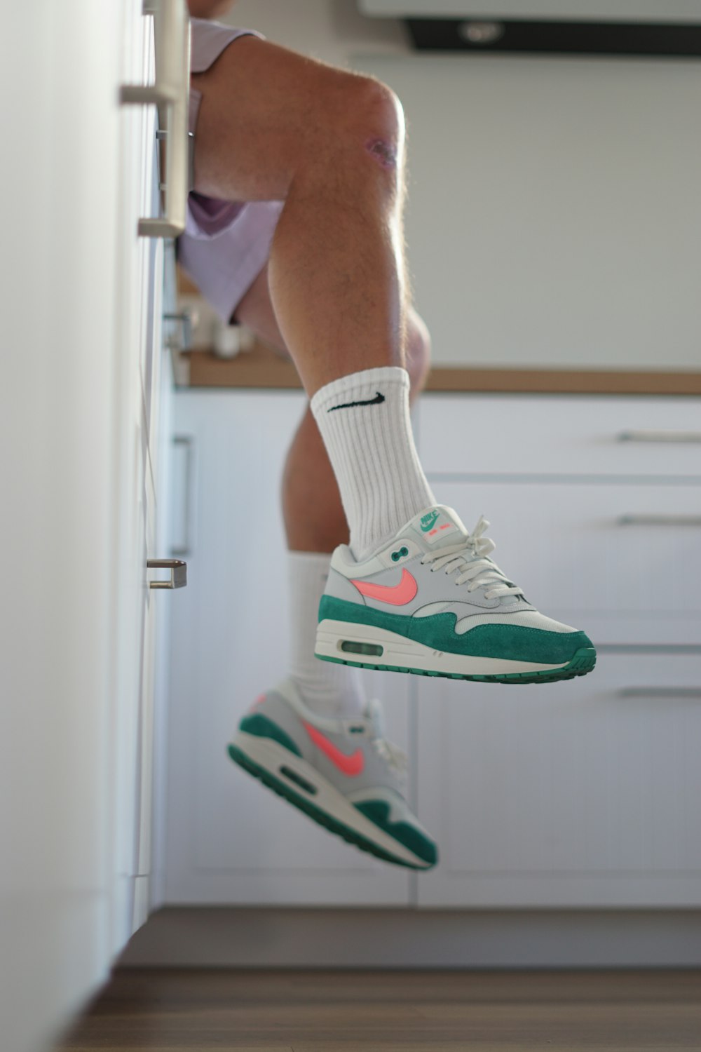 a man sitting on top of a kitchen counter