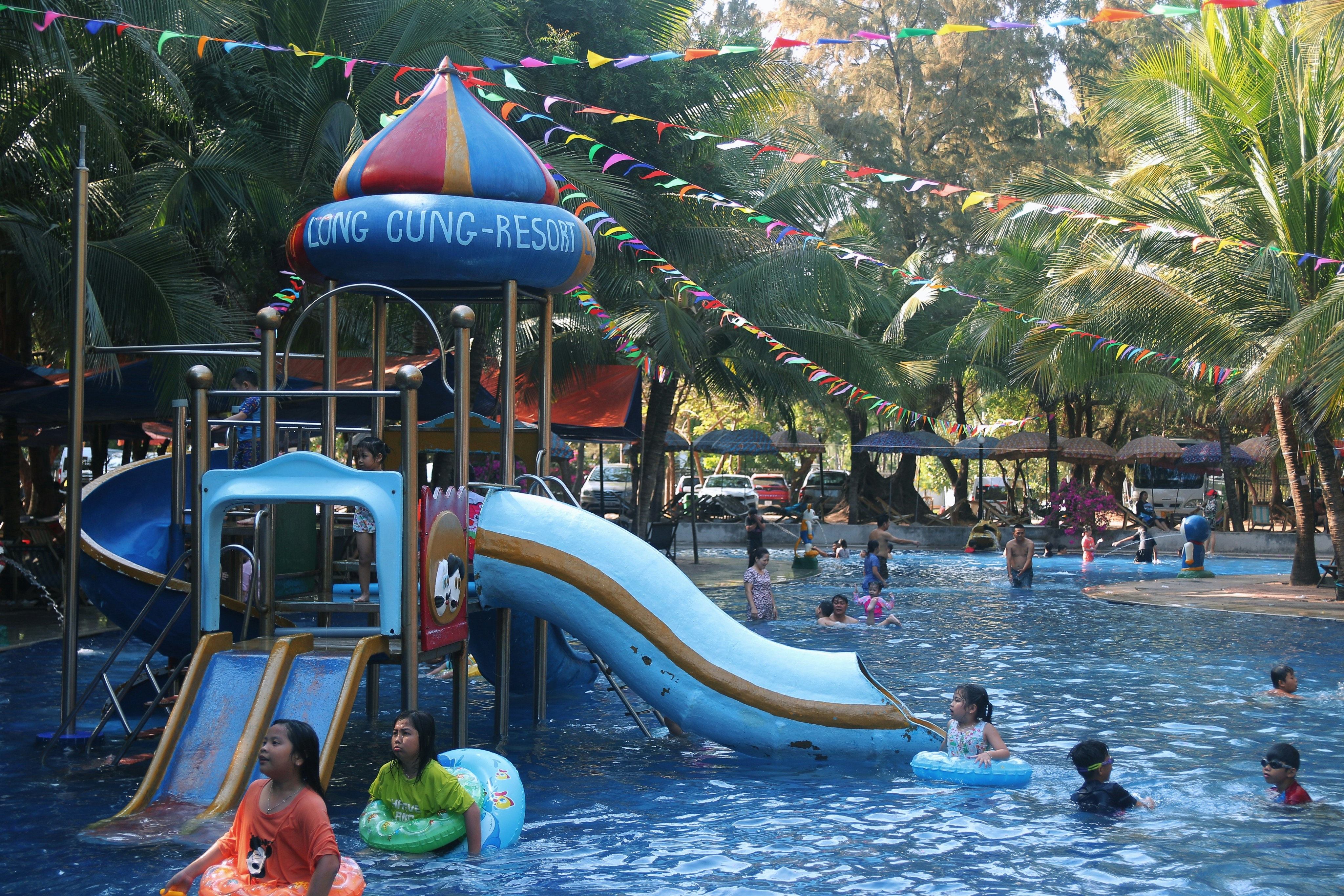 A busy, family-friendly public pool with people swimming, playing, and lounging in the sun - best outdoor pool chicago
