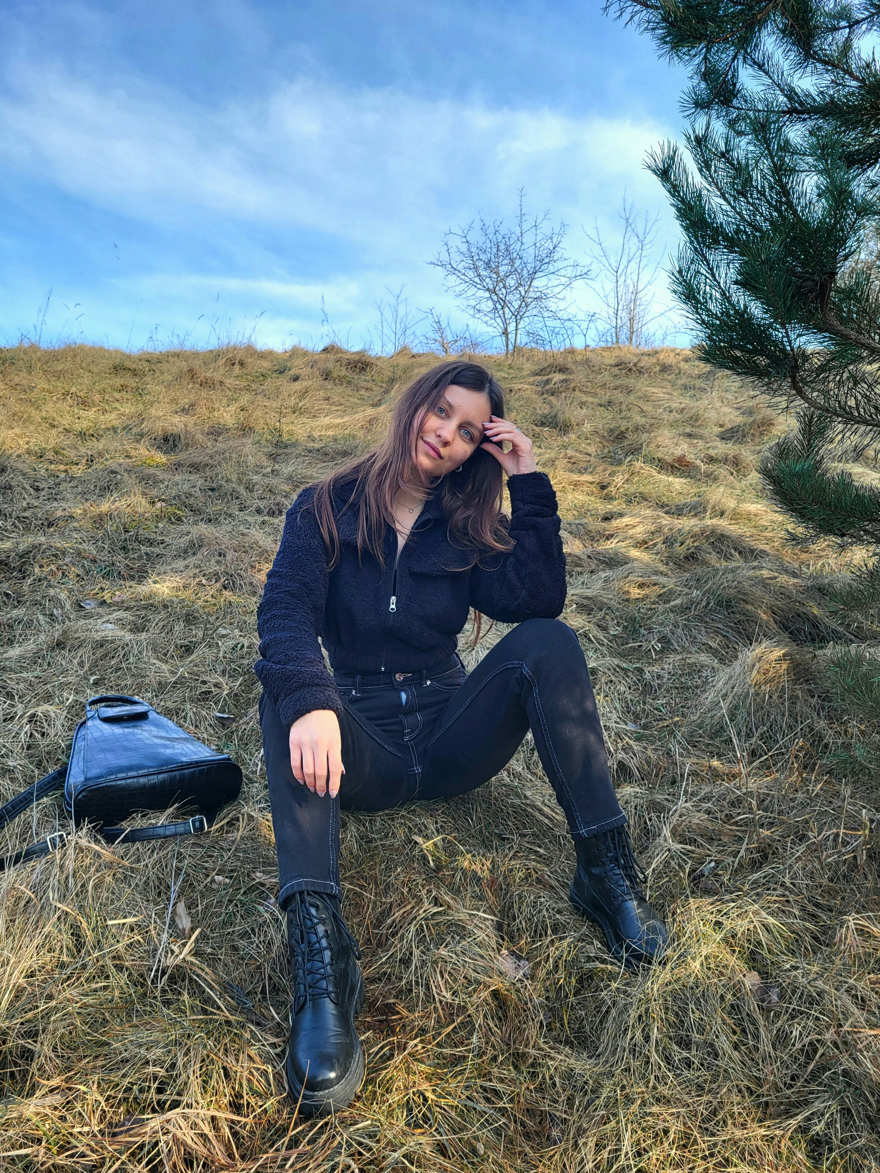 a woman sitting on the ground in a field