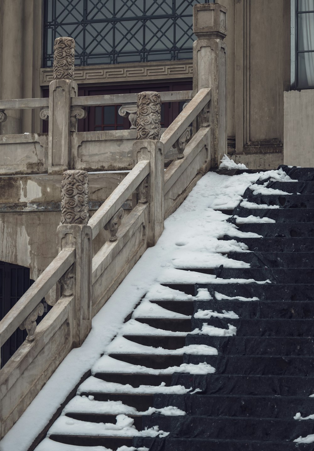 a set of stairs covered in snow next to a building