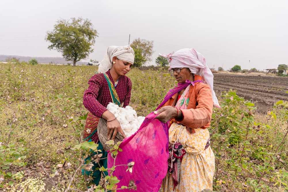 two women standing in a field holding something