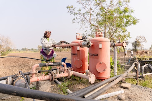 a woman standing next to a large pipe