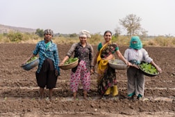 a group of women standing in a muddy field