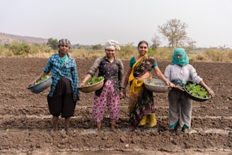 a group of women standing in a muddy field