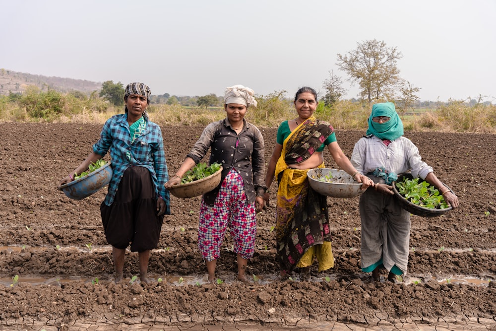 a group of women standing in a muddy field