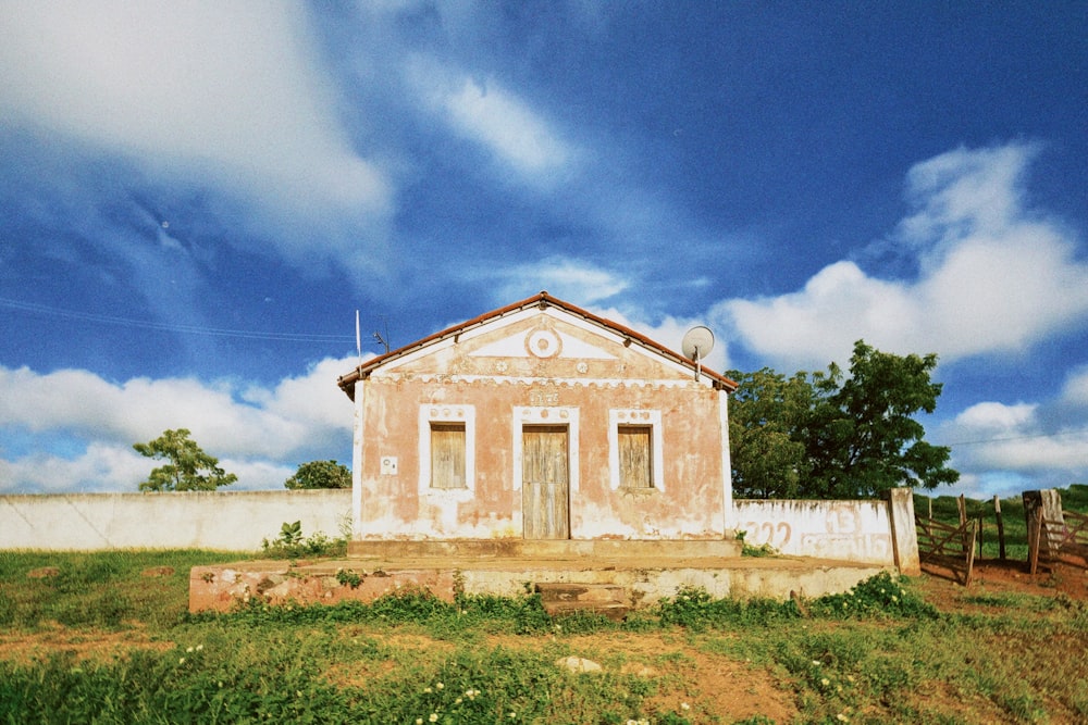 an old building sitting in the middle of a field